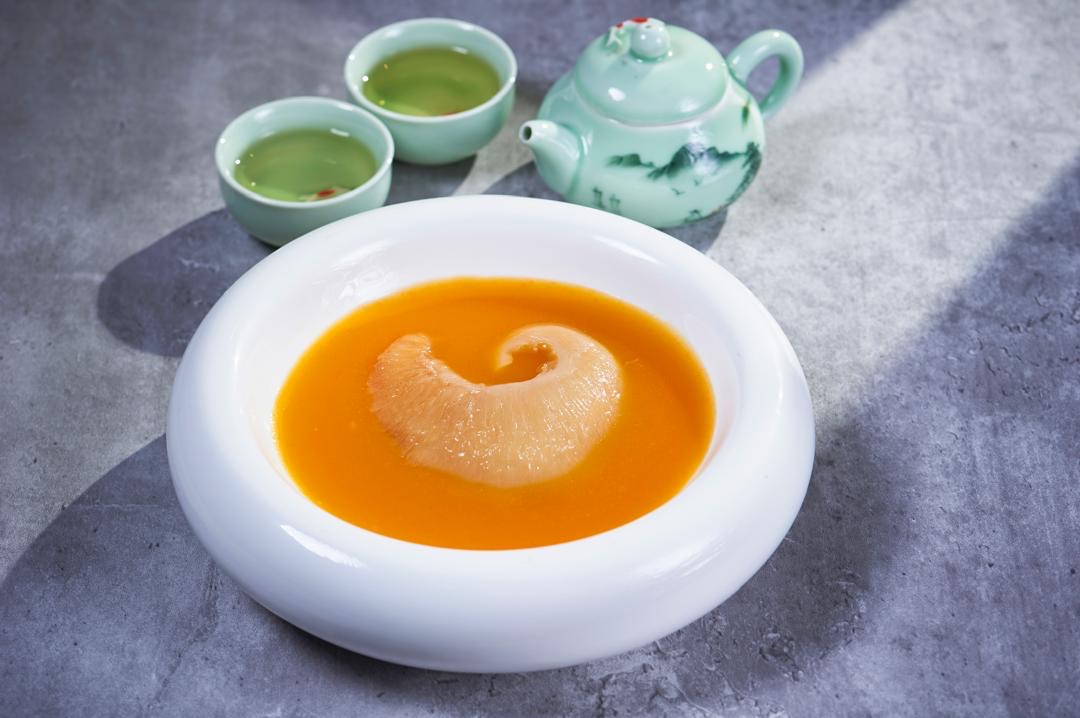 Fish maw double-boiled soup with a celadon teapot on grey stone